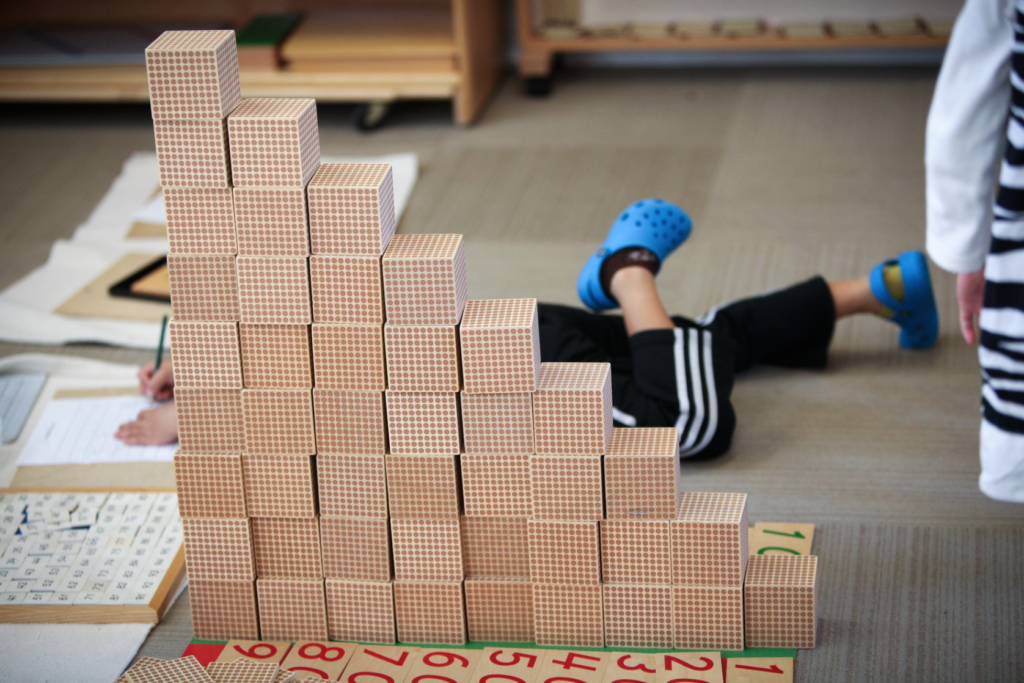 A child learns counting with actual objects and beads.